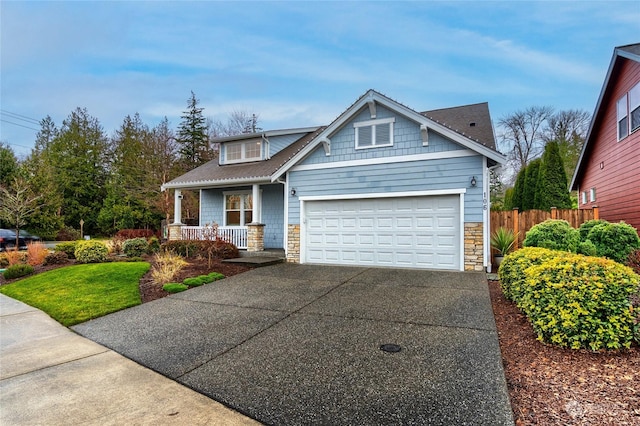 craftsman-style house with a garage, a front yard, and covered porch