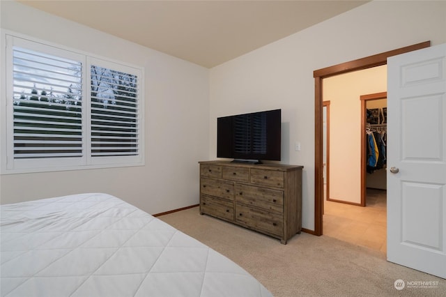 carpeted bedroom with a spacious closet and a closet