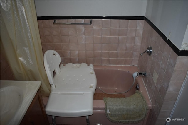 bathroom featuring vanity, tile walls, and a washtub