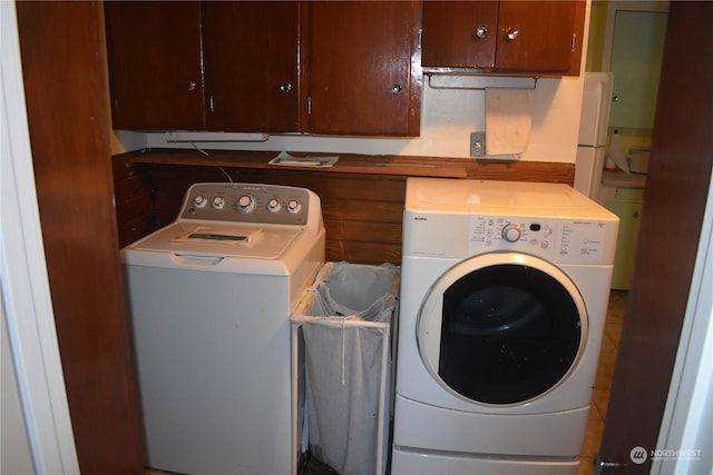 clothes washing area featuring cabinets and washer and dryer