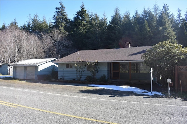 single story home featuring a garage and an outbuilding