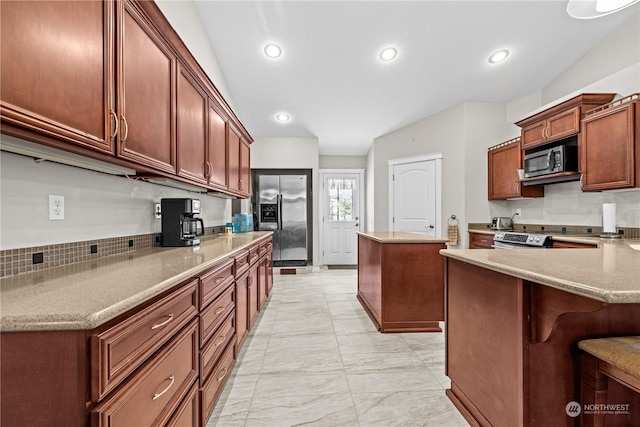 kitchen featuring appliances with stainless steel finishes, a center island, and a breakfast bar area