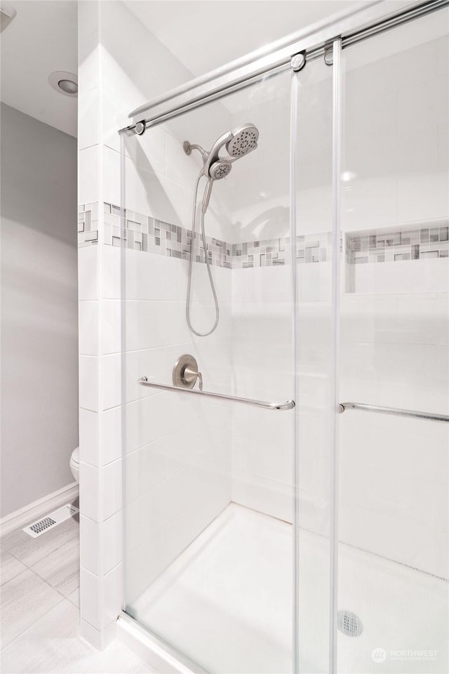 bathroom featuring an enclosed shower and toilet