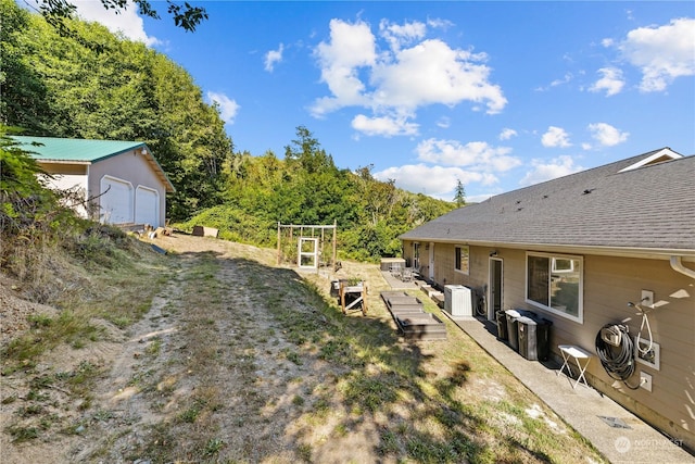 view of yard with a garage and central AC unit