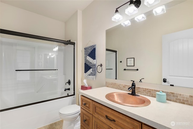 full bathroom featuring vanity, combined bath / shower with glass door, backsplash, and toilet