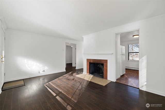 unfurnished living room with ornamental molding, a brick fireplace, dark wood-type flooring, and baseboard heating