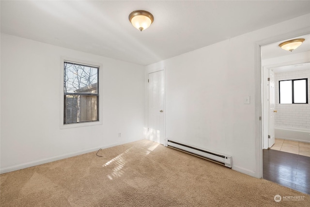 carpeted empty room featuring a baseboard radiator