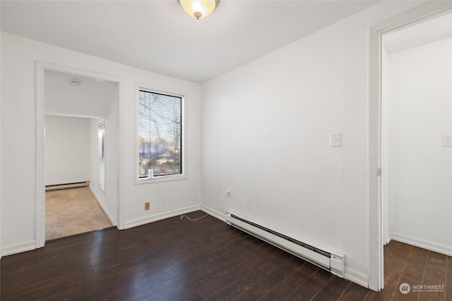 unfurnished room featuring baseboard heating and dark hardwood / wood-style floors