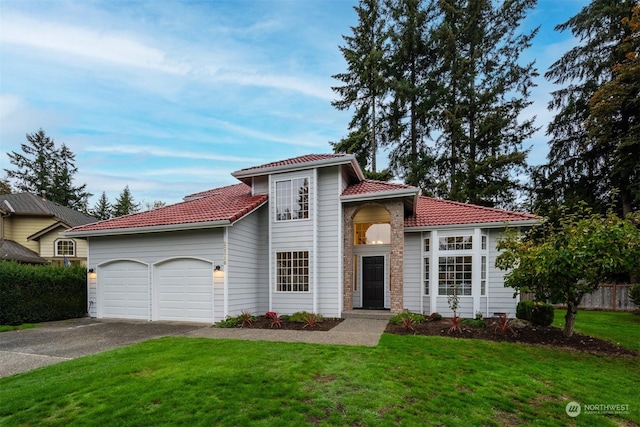 mediterranean / spanish house with a garage and a front yard