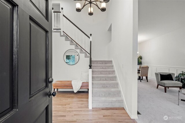 foyer entrance with light wood-type flooring and a notable chandelier