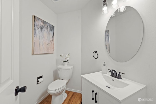 bathroom with hardwood / wood-style flooring, vanity, and toilet