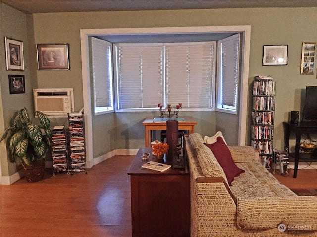 office with dark wood-type flooring, an AC wall unit, and a healthy amount of sunlight