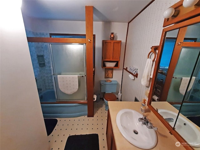 full bathroom featuring vanity, shower / bath combination with glass door, and toilet