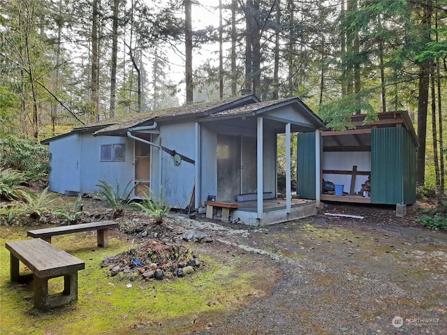 rear view of house featuring an outdoor structure