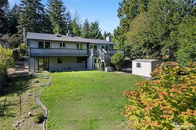 back of property with a wooden deck, a storage shed, and a yard