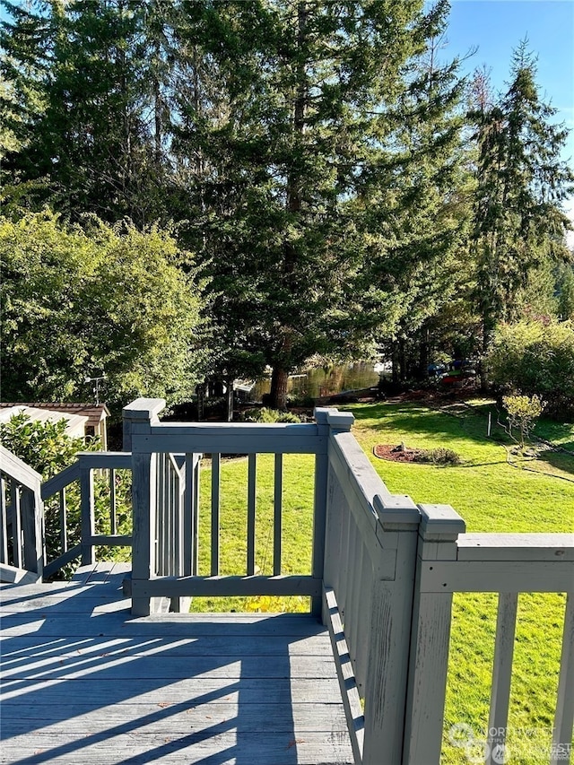 wooden deck featuring a lawn