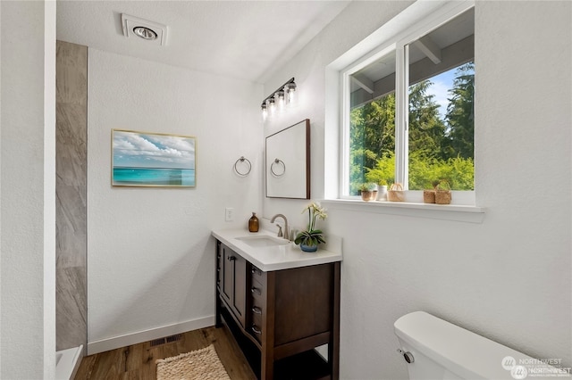 bathroom featuring hardwood / wood-style flooring, vanity, and toilet