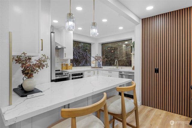 6111 145th St SW, Edmonds, WA 98026 - kitchen with light stone countertops, appliances with stainless steel finishes, pendant lighting, and white cabinets