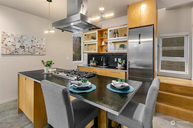 kitchen with a kitchen bar, sink, island range hood, hanging light fixtures, and stainless steel appliances