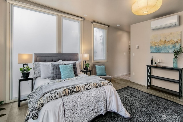 bedroom featuring hardwood / wood-style flooring and a wall mounted air conditioner