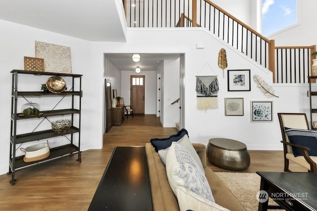 living room with a towering ceiling, dark hardwood / wood-style floors, and a wealth of natural light