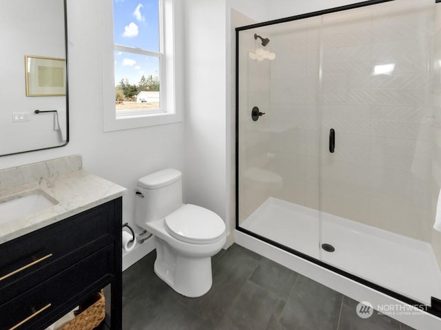 bathroom featuring vanity, tile patterned floors, a shower with door, and toilet