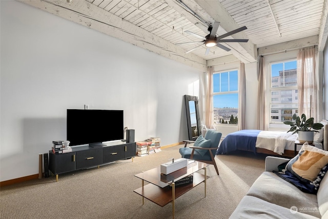 living room featuring beamed ceiling, carpet flooring, wooden ceiling, and ceiling fan