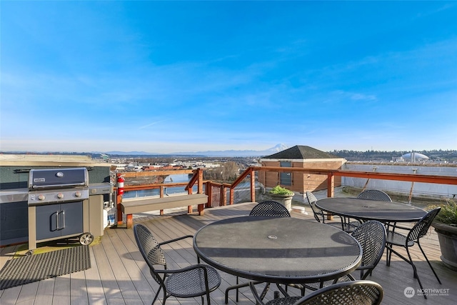 wooden deck with a water and mountain view