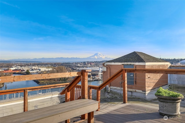 wooden deck featuring a water and mountain view