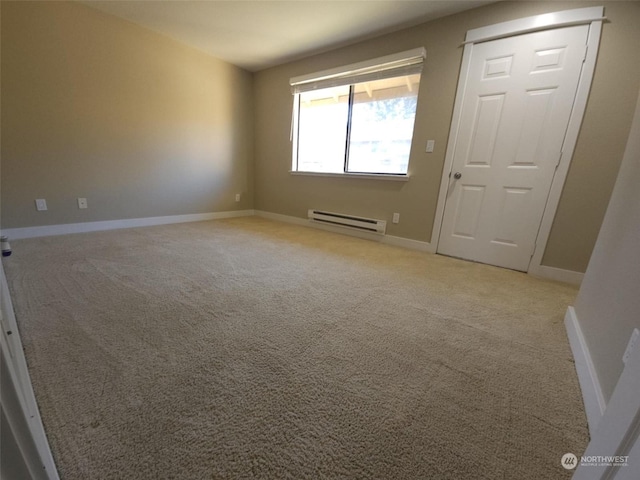 spare room with a baseboard radiator and light colored carpet