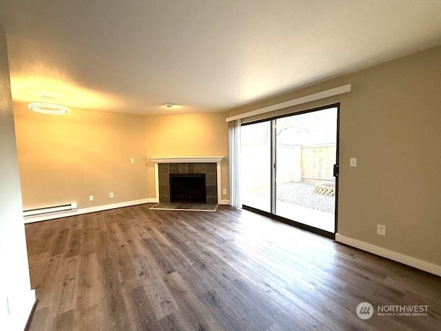 unfurnished living room featuring a tile fireplace, hardwood / wood-style floors, and baseboard heating