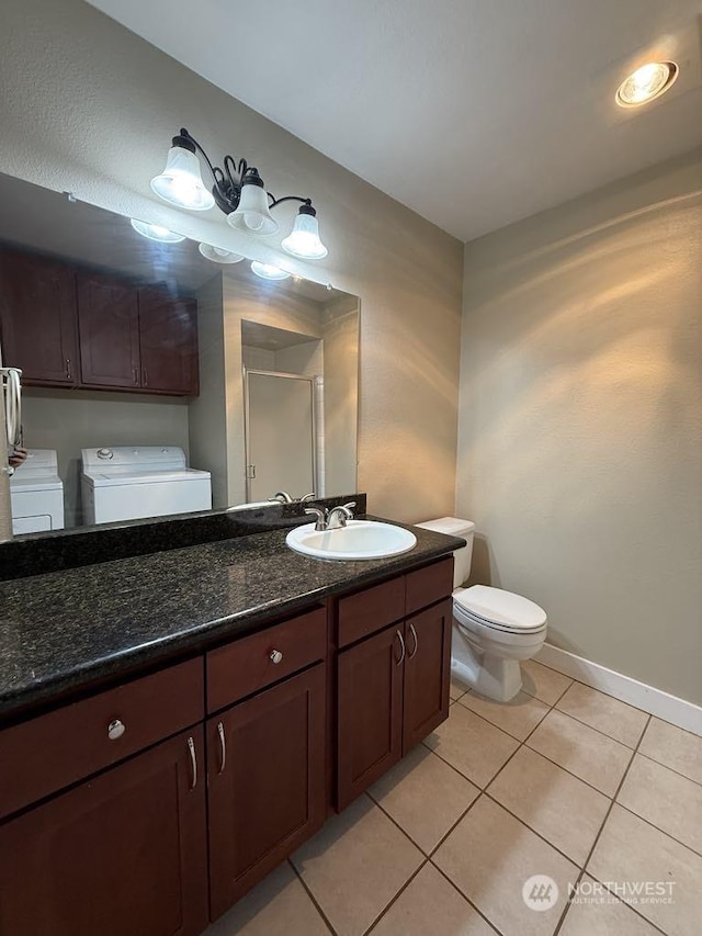 bathroom with tile patterned flooring, vanity, independent washer and dryer, and toilet