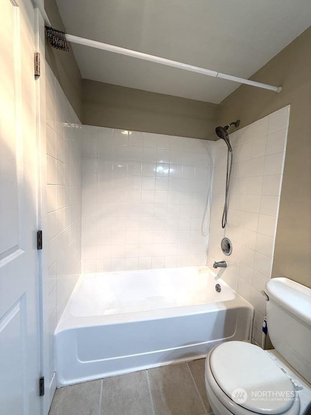 bathroom with tiled shower / bath combo and toilet