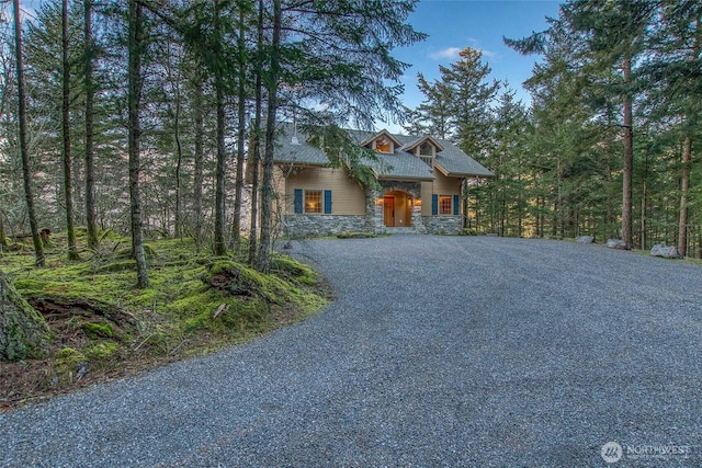 chalet / cabin featuring driveway and stone siding