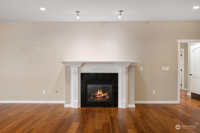 details with hardwood / wood-style flooring and a tile fireplace