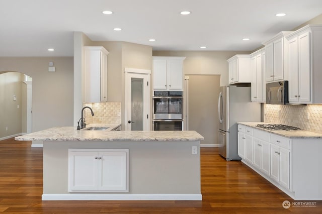 kitchen with white cabinetry, stainless steel appliances, kitchen peninsula, and sink