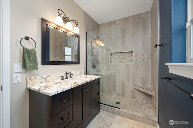 bathroom featuring vanity, tile patterned floors, and a tile shower