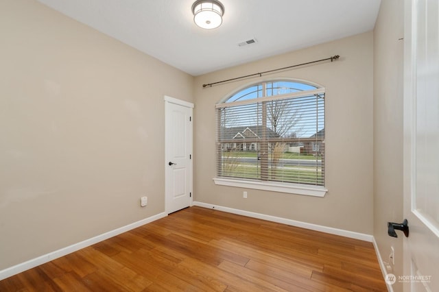 unfurnished room with hardwood / wood-style flooring