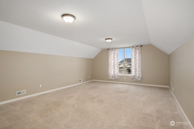 additional living space featuring carpet flooring and vaulted ceiling