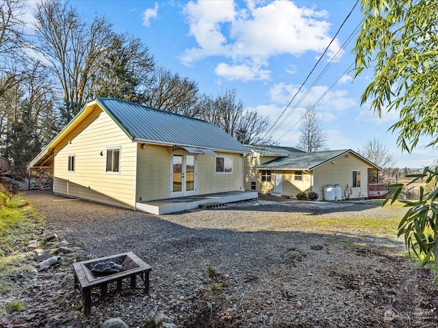 back of property featuring a patio and a fire pit