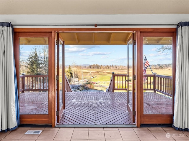 entryway featuring a rural view and light tile patterned floors