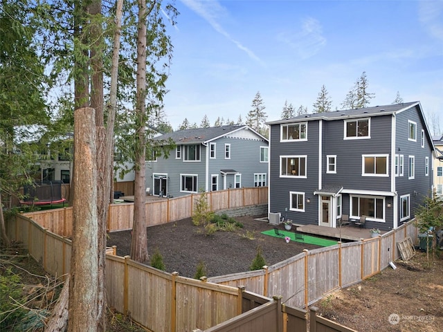 back of house with a residential view, a fenced backyard, a wooden deck, and central air condition unit