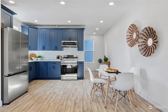 kitchen with decorative backsplash, light wood-type flooring, stainless steel appliances, and blue cabinets