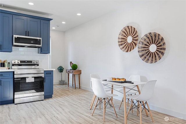 kitchen featuring tasteful backsplash, appliances with stainless steel finishes, light hardwood / wood-style floors, and blue cabinetry