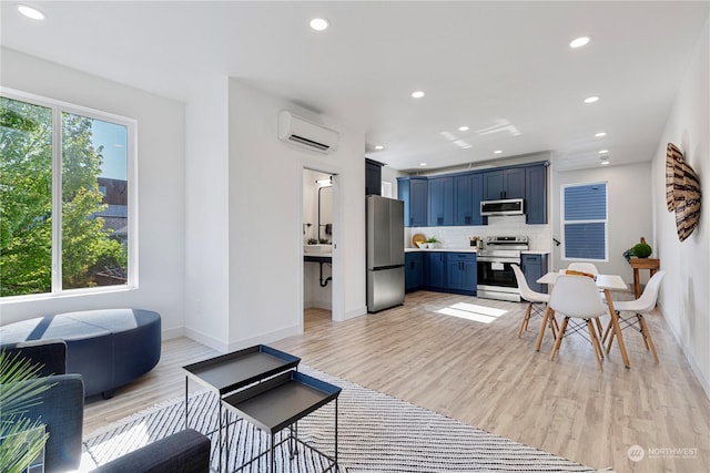 living room featuring light hardwood / wood-style flooring and an AC wall unit