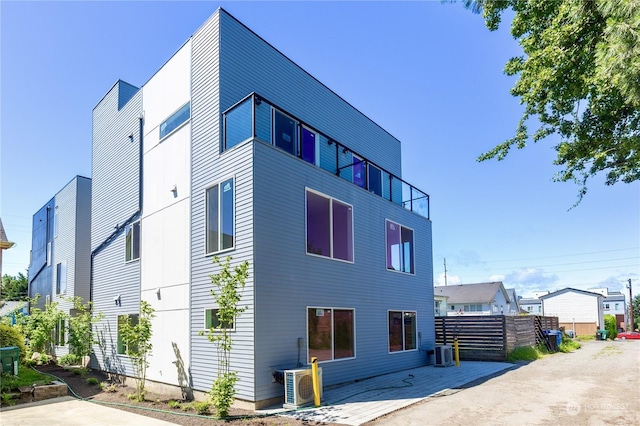 view of side of property with ac unit, central AC, and a patio area