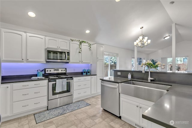 kitchen with lofted ceiling, sink, hanging light fixtures, appliances with stainless steel finishes, and white cabinets