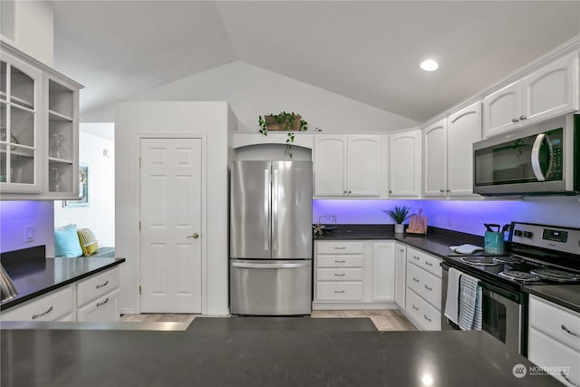 kitchen with white cabinetry, stainless steel appliances, and vaulted ceiling