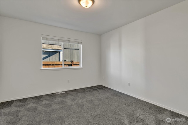 spare room with dark carpet