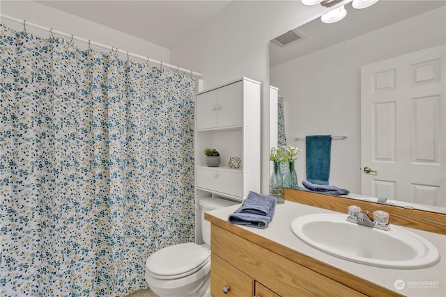 bathroom featuring vanity, curtained shower, and toilet